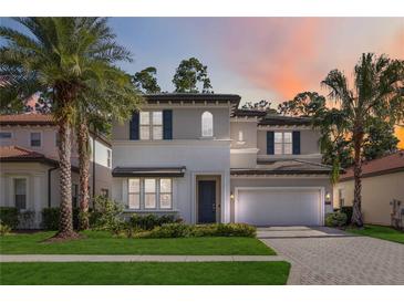 Two-story house with gray and white exterior, a dark door, and a brick driveway at 10159 Royal Island Ct, Orlando, FL 32836