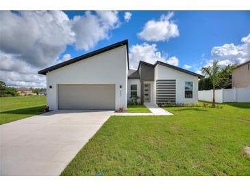 Modern, single-story home with a two-car garage and well-manicured lawn at 1877 Snapper Dr, Kissimmee, FL 34759