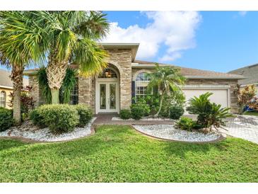 Charming single-story home with stone exterior, lush landscaping, and a two-car garage at 2108 Drive Way, Kissimmee, FL 34746