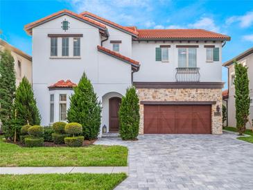 Two-story house with red tile roof, stone accents, and a large driveway at 10564 Royal Cypress Way, Orlando, FL 32836