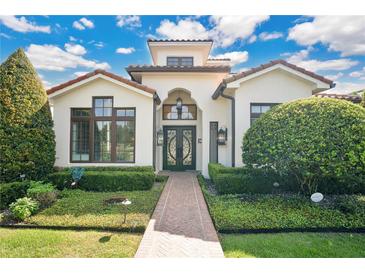 Stunning two-story home with brick pathway, lush landscaping, and a Mediterranean-style design at 1010 N Pennsylvania Ave, Winter Park, FL 32789