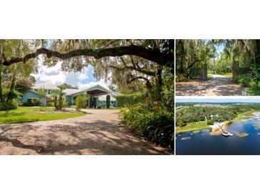 Blue house with covered entry, long driveway, and lush landscaping at 17017 Marsh Rd, Winter Garden, FL 34787