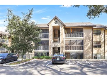 Two-story condo building with balconies, screened porches, and ample parking at 623 Dory Ln # 308, Altamonte Springs, FL 32714
