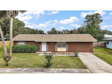 Ranch-style home with brown exterior, small yard and driveway at 3375 Sw 147Th Lane Rd, Ocala, FL 34473