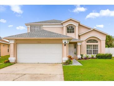 Two-story house with a white garage door and landscaped lawn at 14646 Brightwell Ct, Orlando, FL 32824