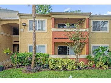 Two-story building with balcony, landscaping, and manicured lawn at 604 Kenwick Cir # 202, Casselberry, FL 32707