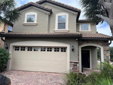 Two-story house with a three-car garage and a nicely landscaped front yard at 9066 Rhodes St, Kissimmee, FL 34747