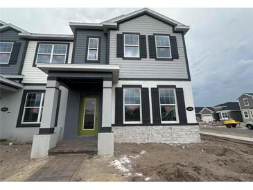 Two-story house with gray and white siding, green door, and dark shutters at 1340 Lumpini St, Saint Cloud, FL 34771