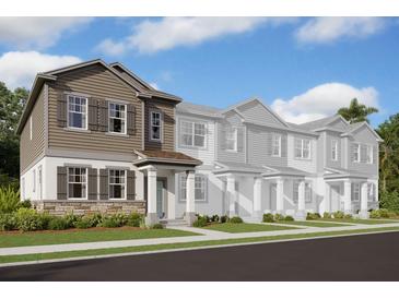 Exterior view of a two-story townhome with brown siding and stone accents at 15877 Tollington Aly, Winter Garden, FL 34787