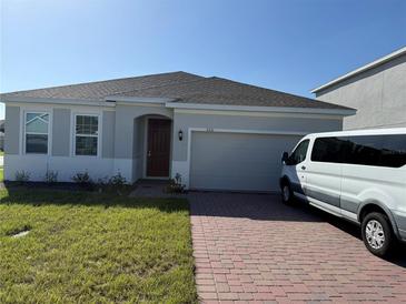 One story home with a two-car garage and a well-maintained lawn at 5231 Maddie Dr, Haines City, FL 33844