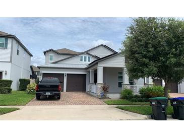 Two story home with gray siding, brown garage doors, and landscaped yard at 14739 Glade Hill Park Way, Winter Garden, FL 34787