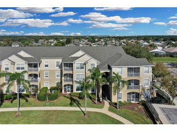 Exterior of a large apartment building with palm trees and landscaping at 8100 Princess Palm Ln # 305, Kissimmee, FL 34747