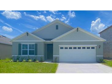 Two-story house with gray siding and two-car garage at 1010 Tupelo Trl, Haines City, FL 33844