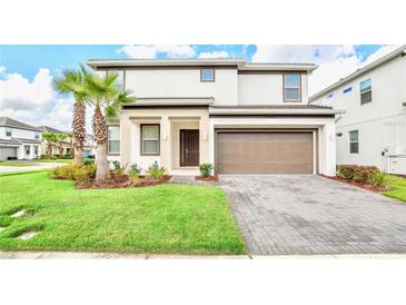Two-story house with brown garage door and palm trees in front at 2610 Calistoga Ave, Kissimmee, FL 34741