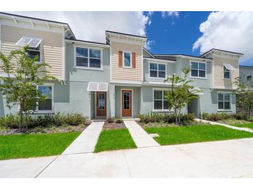 Exterior view of a two-story townhome with light-colored siding and landscaping at 1812 Tropical Palms Cir, Kissimmee, FL 34747