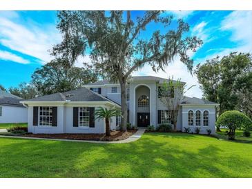 Two-story house with gray siding, dark windows, and a lush green lawn at 6893 Hidden Glade Pl, Sanford, FL 32771