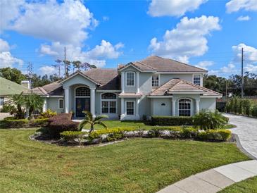 Two-story house with tile roof, landscaping, and driveway at 9810 Camberley Cir, Orlando, FL 32836