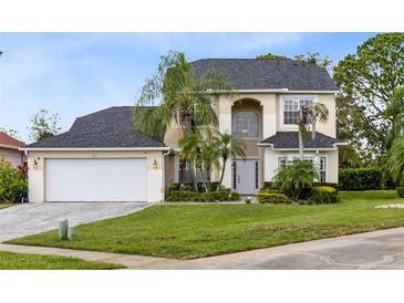Two-story house with a large front yard, two car garage and palm trees at 2815 Crane Trace Cir, Orlando, FL 32837