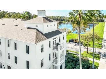 White building with a balcony, lake view, and palm trees at 770 Siena Palm Dr # 305, Celebration, FL 34747