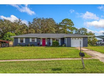 Charming ranch home with red door and well-manicured lawn at 1533 Findlay St, Deltona, FL 32725