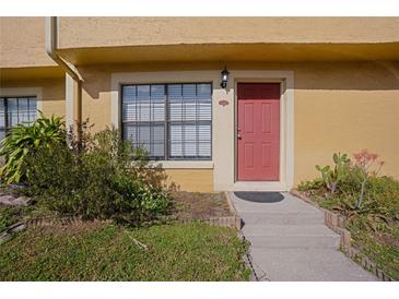 Inviting condo entrance with red door, landscaping, and walkway at 3390 Cedar Spring Pl # 163, Winter Park, FL 32792