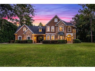 Two-story house with stone and stucco exterior at dusk at 8407 River Branch Pl, Sanford, FL 32771
