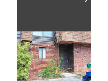 Brick building exterior with a brown door and landscaping at 1836 N Crystal Lake Dr # 31, Lakeland, FL 33801