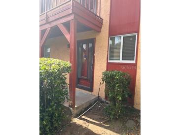 Condo entrance with red door and shrubs at 2802 N Powers Dr # 18, Orlando, FL 32818