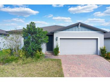 Single-story home with gray siding, brick driveway, and landscaping at 416 Mckenna Dr, Winter Haven, FL 33881