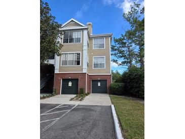 Tan three-story building with two-car garages at 13103 Mulberry Park Dr # 817, Orlando, FL 32821