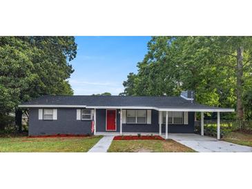 Charming one-story home with a red door and landscaped yard at 1419 Ne 21St St, Ocala, FL 34470