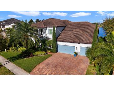 Two-story house with brown tile roof, light-colored siding, and a three-car garage at 16659 Broadwater Ave, Winter Garden, FL 34787