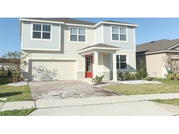 Two-story house with gray siding, red door, and a paved driveway at 7916 Waterfield Ave, Orlando, FL 32832