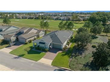 Aerial view of a house with a golf course in the background at 5466 Nw 35Th Lane Rd, Ocala, FL 34482