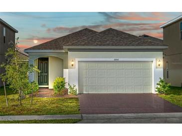 One-story home with two-car garage and landscaping at 6886 Wilson Hammock Ave, Groveland, FL 34736