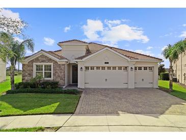 Beautiful two-story house with a three-car garage and stone accents at 1142 Trappers Trail Loop, Davenport, FL 33896