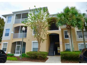 Two-story condo building with balconies and palm trees at 6214 Stevenson Dr # 303, Orlando, FL 32835