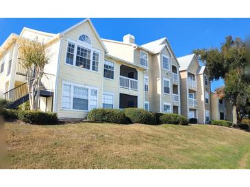 Tan colored multi-unit building with grassy lawn at 1065 S Hiawassee Rd # 1428, Orlando, FL 32835