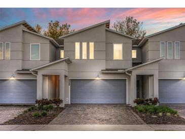 Modern townhouse exterior with gray siding and paver driveway at 3340 Bellissimo Ave, Kissimmee, FL 34746