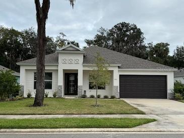 Charming one-story home with dark brown garage door and landscaped lawn at 3041 Adrian Dr, Ormond Beach, FL 32174