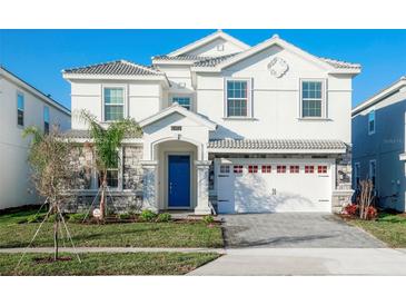 Two-story house with a blue door, white exterior, and a three-car garage at 1540 Maidstone Ct, Davenport, FL 33896