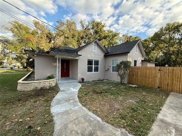 Newly renovated house with a red door, walkway, and wood fence at 1009 Herndon St, Leesburg, FL 34748