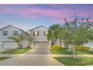 Two-story house with gray siding, landscaping, and a paved driveway at 2468 Dubai St, Kissimmee, FL 34747