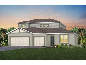 Two-story house with gray siding, two-car garage, and green lawn at 15065 Willow Ridge Dr, Montverde, FL 34756