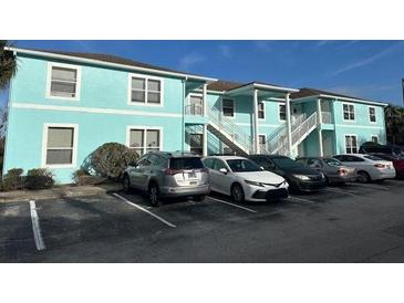 Light teal condo building with ample parking and landscaping at 3128 Sun Lake Ct # A, Kissimmee, FL 34747