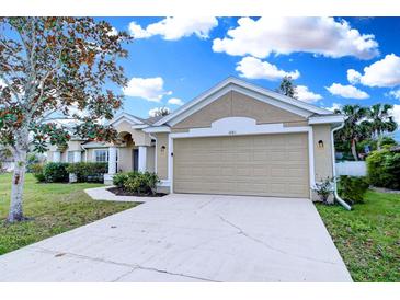 Tan house with a two-car garage and manicured lawn at 1261 Sherbrook Dr, Deltona, FL 32725