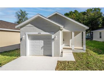 Newly constructed home with a white garage door and light gray exterior at 1991 Hollywood Ave, Eustis, FL 32726