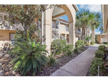 Well-maintained condo building with landscaped grounds and walkway at 2711 Emerald Lake Ct, Kissimmee, FL 34744