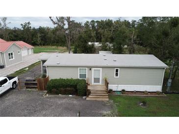Single-wide mobile home with grey siding, steps, and landscaping at 1111 Sunflower Trl, Orlando, FL 32833