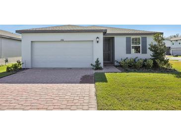One-story house with gray shutters, a paved driveway, and a well-manicured lawn at 4702 Jasmine Cir, Leesburg, FL 34748